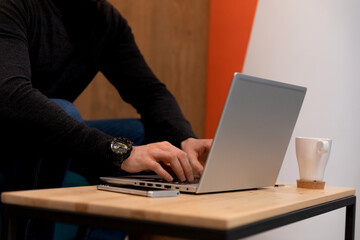 A programmer coding at lap top at coworking space