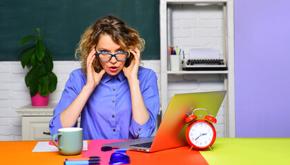 Wall Mural - Teacher job. Female teacher with laptop in classroom. Learning and education. Professional teacher or university professor sitting at table with notebook in auditorium. Student studying in university.