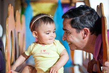 Wall Mural - Beautiful ten months baby girl playing with her dad. Early stimulation for toddlers concept.