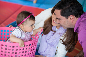 Wall Mural - Beautiful ten months baby girl playing with her parents. Early stimulation for toddlers concept.