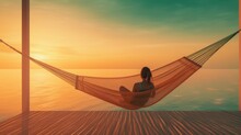 Young Woman Enjoying Her Vacation Relaxed In A Hammock With A Sunset In The Background And The Sea