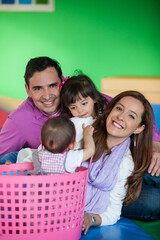 Wall Mural - Young parents playing with their daughters. Early stimulation for toddlers and children concept.