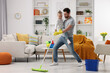 © New Africa - Spring cleaning. Father and daughter having fun while tidying up together at home