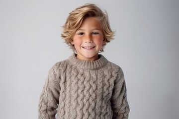 Wall Mural - Portrait of a cute little boy with blond hair in a knitted sweater