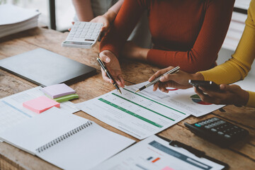 Wall Mural - business woman Financial audit administrator and secretary doing reports, calculating the balance. Calculate with a calculator about business growth data and point out financial accounting charts.