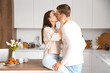 © Pixel-Shot - Happy young couple kissing in kitchen