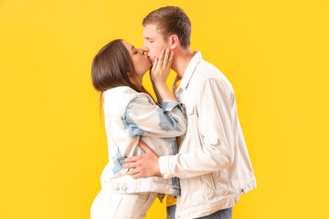 Poster - Happy young couple kissing on yellow background