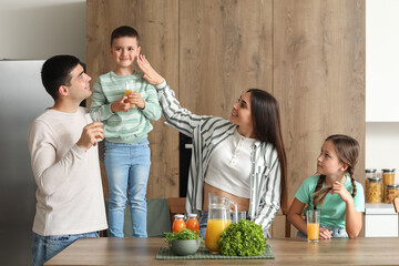 Sticker - Happy parents with their little children drinking orange juice in kitchen