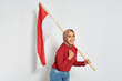 Excited young Asian women celebrate Indonesian independence day on 17 August by holding the Indonesian flag isolated over white background