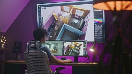 Young 3D designer creates modern house interior, works on design project at home office on computer and big digital screen with professional software interface and tools for 3D modeling and planning.