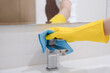Woman, housewife wiping faucet with cloth.