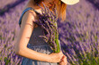 Woman holding a bouquet of flowers in a lavender field