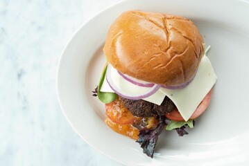 Sticker - Closeup of a delicious hamburger on a white plate