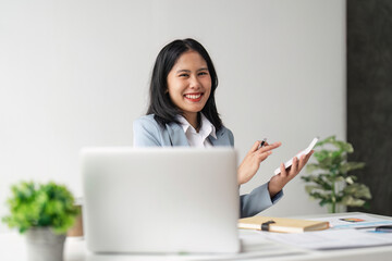 Wall Mural - Young businesswoman using a calculator to calculate business principles. Accounting statistics concept at the office