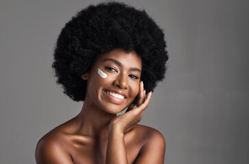 black woman, cream on face and beauty with cosmetics product, skincare and dermatology on studio bac