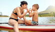 Lake, nature with mother and son on paddle board, relax outdoor with summer holiday and travel. Adventure, freedom and fun, family with woman and boy child in swimsuit, vacation and bonding together