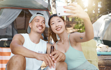 Canvas Print - Selfie, love and young couple on a camp in the woods for a summer weekend trip or holiday. Happy, smile and man with beer while his girlfriend taking a picture in forest on outdoor vacation together.