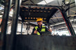 © kanpisut - Man worker at forklift driver happy working in industry factory logistic ship. Man forklift driver in warehouse area. Forklift driver sitting in vehicle in warehouse.