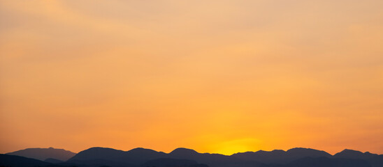Wall Mural - orange sky over silhouette mountain in the morning.