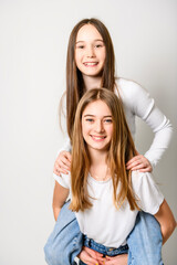 Wall Mural - Two Young pre teen best friend girl on studio white