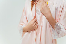 details of a pink nightgown on a girl. photo session of a silk women's sleep set on a woman. women's colored pajamas
