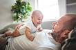 © Louis-Paul Photo - Portrait of a beautiful father, with her nursing baby on sofa