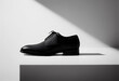 © Cala Serrano - Male shoes isolated in a minimalist scene with a relaxing black and white shadows in the background.