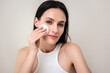 portrait of woman remove makeup with cotton sponge and micellar water