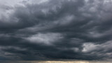 Fototapeta  - The dark sky with heavy clouds converging and a violent storm before the rain.Bad or moody weather sky and environment. carbon dioxide emissions, greenhouse effect, global warming, climate change