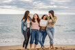 © PintoArt - group of multiracial diverse female friends together on the beach smile and pose for selfie photo happy