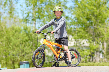 Wall Mural - child having fun outdoors driving bike for children on playground