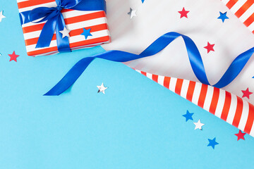 Wall Mural - 4th of July, USA Presidents Day, Independence Day. Flat lay top view of patriotic wrapping paper and gift box twinkling confetti on blue background with space, promotion or greeting message, banner