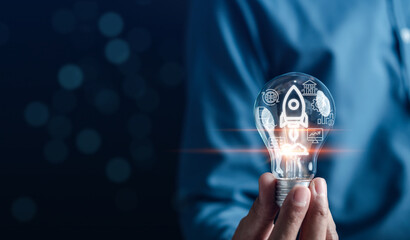 Aufkleber - Hand Business holding light bulb with rocket launch icon, Fast start up business to goal and success objective target and solution concept.