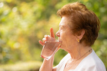 Senior Drinking Water In Summer Outdoors