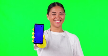 Sticker - Asian woman, cleaner and phone in thumbs up on green screen for approval against a studio background. Portrait of female person or main show mobile smartphone with like emoji, yes or tracking markers