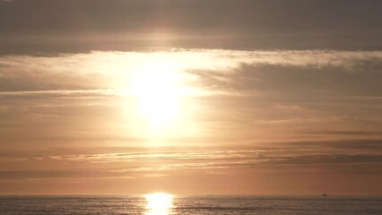 Wall Mural - Full sunset time lapse over large body of water and a beautiful warm lit sky turns to black as sun falls behind horizon.