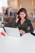 © Igor Kardasov - Happy lady receiving phone call while using netbook