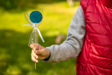 The Child Holds A Blue Lollipop In His Hand.Treat The Child With Candy On A Stick.Sweet Treat.