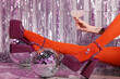 © New Africa - Woman in orange tights and pink high heeled shoes with drink among disco balls indoors, closeup