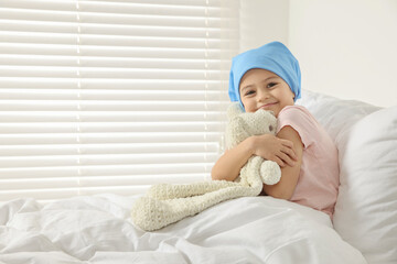 Canvas Print - Childhood cancer. Girl hugging toy bunny in hospital