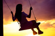 © Valmir Fernando - A silhouette of a woman swinging on a swing at sunset, with a colorful sky in the background. Selective focus