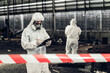 © kanpisut - Scientist wear Chemical protection suit check danger chemical, working at dangerous zone in Red and White Lines of barrier tape. Red and white Hazardous restricted area factory safety worker industry