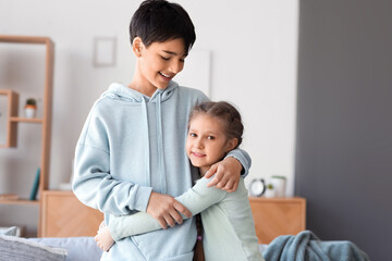 Poster - Little girl hugging her brother at home