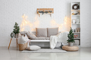 Interior of living room with Christmas trees, couch and glowing lights