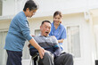 © amorn - Nurse and patient Asian senior man. Nurse caring Asian senior man on wheelchair outdoor at hospital. Asian nurse taking care patient senior man on wheelchair with kindly