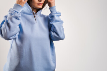 Wall Mural - young girl wears a light blue hoodie. blue hoodie mock-up. hooded sweatshirt