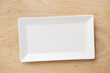 White rectangular ceramic plate on a wooden table, top view