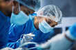 © Wesley JvR/peopleimages.com - Hospital knife, surgery and doctors in theatre for medical support, teamwork and emergency healthcare with focus. Doctor, nurse and surgeon face mask, patient check and tools in operating room