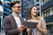© NDABCREATIVITY - Two desingers, business people working on a project together in urban background