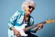 Portrait of a cool trendy old woman playing a guitar on blue studio background. Generative AI